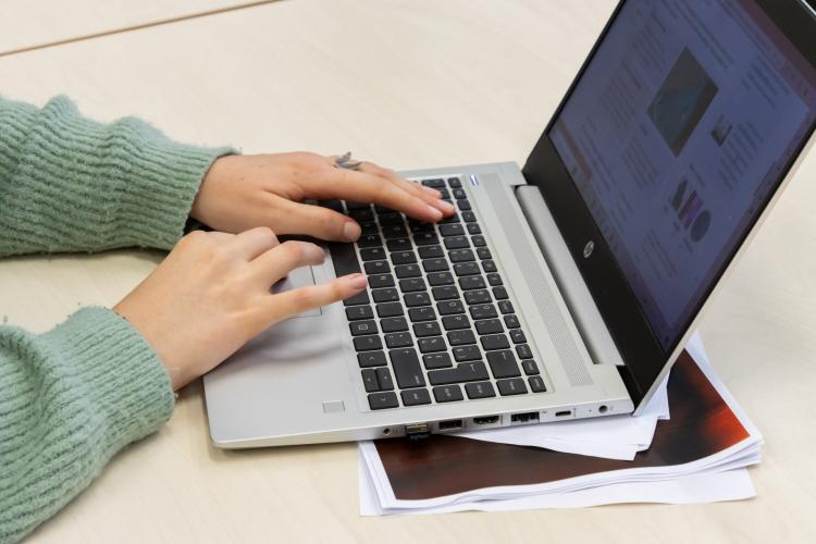 Close-up handen aan laptop